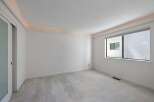 Experience modern living in this spacious room featuring a sleek sliding door and a large window that floods the space with natural light.