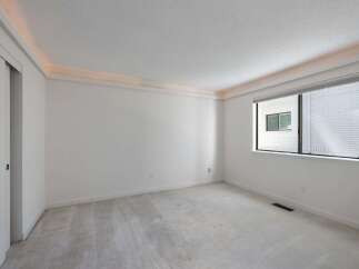 Experience modern living in this spacious room featuring a sleek sliding door and a large window that floods the space with natural light.