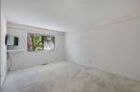 This spacious room features a large window offering a view of lush greenery, perfect for natural light.