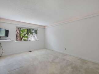 This spacious room features a large window offering a view of lush greenery, perfect for natural light.