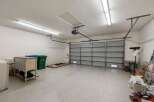 Discover ample storage and organization potential in this spacious garage, featuring a durable epoxy-coated floor and a modern roll-up door.