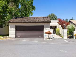 Discover this charming single-family home featuring a welcoming facade with light brick and a dark roll-up garage door.
