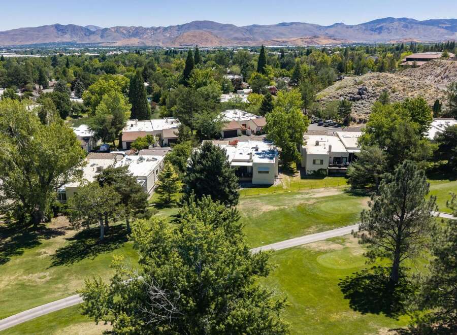 Experience luxury living with this stunning aerial view of homes nestled beside a pristine golf course.