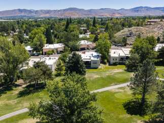 Experience luxury living with this stunning aerial view of homes nestled beside a pristine golf course.