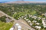 Discover this stunning aerial view showcasing a vibrant community nestled beside a lush golf course and serene water features.