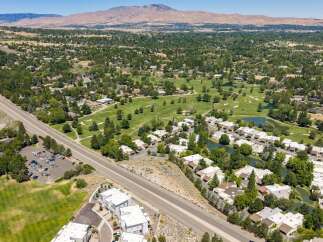 Discover this stunning aerial view showcasing a vibrant community nestled beside a lush golf course and serene water features.