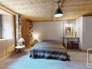 Experience rustic charm in this cozy bedroom featuring a plush, fur-covered bed and warm wooden accents throughout.