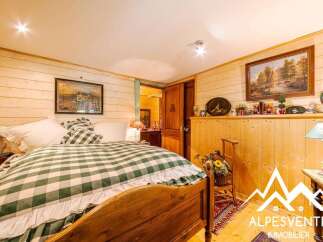 Experience rustic charm in this cozy bedroom, featuring a classic wooden bed adorned with a green and white checkered comforter.