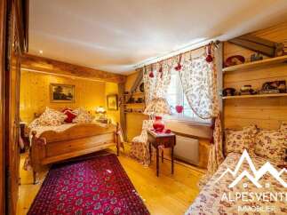 Experience rustic charm in this cozy bedroom featuring a beautiful wooden bed adorned with floral linens and plush pillows.
