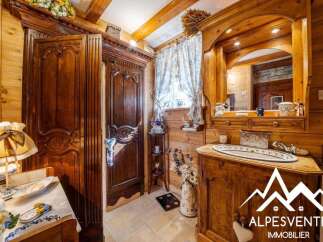Step into a charming bathroom with rustic wooden walls and exposed beams, evoking a cozy cabin feel.