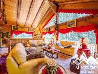 Experience rustic charm in this cozy log cabin living room, featuring plush sofas adorned with faux fur throws, a rustic wooden coffee table, and a grand stone fireplace.