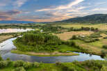 Discover this stunning rural property featuring a serene river winding through lush green landscapes and mature trees.