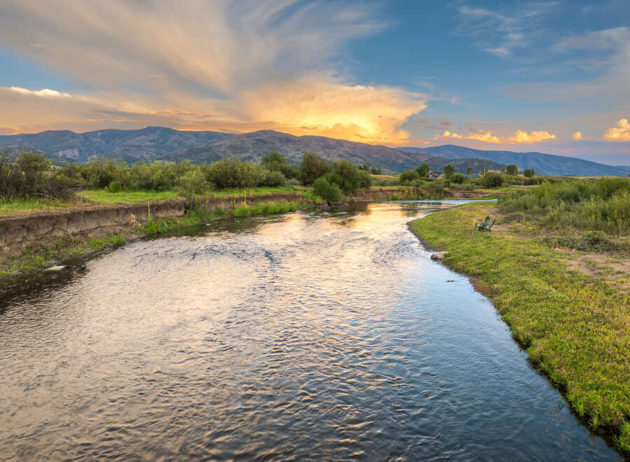 Experience serene living with this stunning property featuring a tranquil river flowing through lush green landscapes.