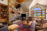 Experience rustic luxury in this stunning living room, featuring a grand stone fireplace and a magnificent bison head mount.