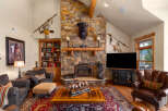 Experience rustic elegance in this stunning living room, featuring a grand stone fireplace as the centerpiece.