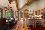 Experience rustic elegance in this stunning mountain home, featuring a grand dining area with a unique antler chandelier and leather seating.