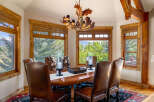 Experience rustic elegance in this stunning dining room, featuring a grand wooden table and plush leather chairs perfect for hosting.