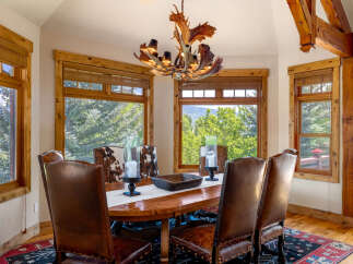 Experience rustic elegance in this stunning dining room, featuring a grand wooden table and plush leather chairs perfect for hosting.