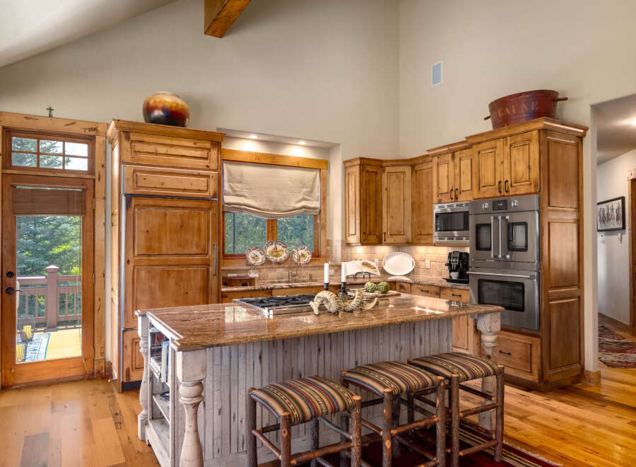 Experience rustic charm in this spacious kitchen featuring custom wood cabinetry and a large granite island perfect for entertaining.