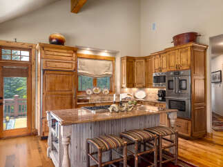 Experience rustic charm in this spacious kitchen featuring custom wood cabinetry and a large granite island perfect for entertaining.