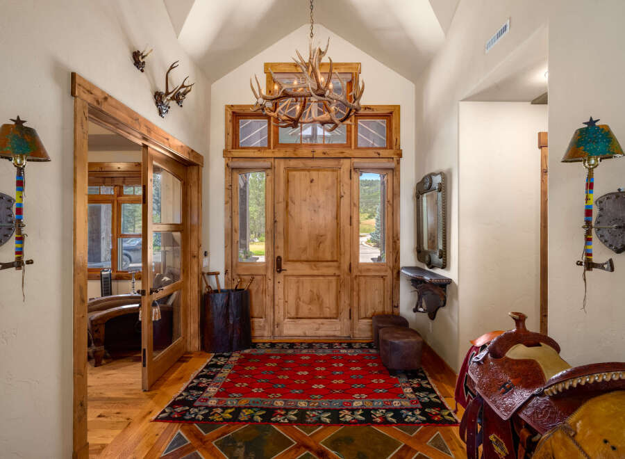 Step into this grand entryway featuring rustic charm and Western-inspired decor.