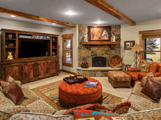 Experience rustic elegance in this inviting living room, featuring a stunning stone fireplace as the centerpiece.