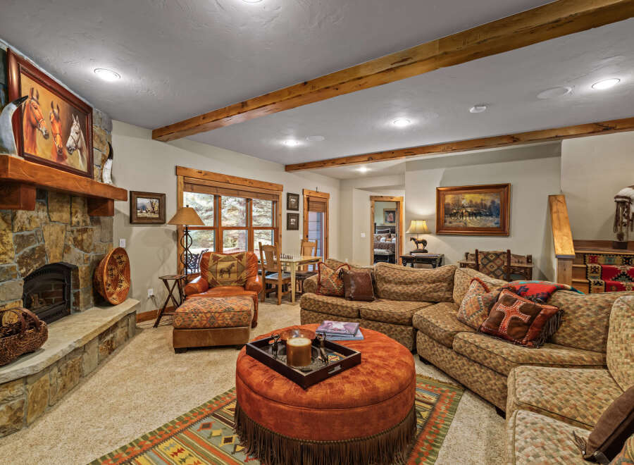 Experience rustic charm in this inviting living room, featuring a grand stone fireplace as the centerpiece.