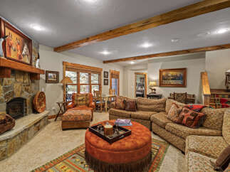 Experience rustic charm in this inviting living room, featuring a grand stone fireplace as the centerpiece.