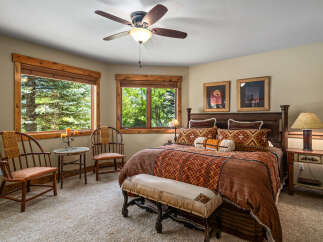 Experience rustic charm in this inviting bedroom, featuring a luxurious king-size bed adorned with Southwestern-inspired textiles.