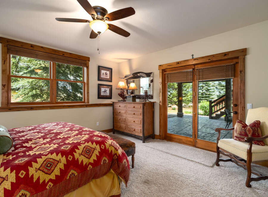 Experience rustic charm in this inviting bedroom, featuring a cozy bed with a Southwestern-inspired comforter and a wooden dresser.