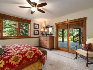 Experience rustic charm in this inviting bedroom, featuring a cozy bed with a Southwestern-inspired comforter and a wooden dresser.