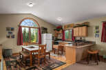 Experience rustic charm in this cozy kitchen, featuring a large arched window with scenic forest views.