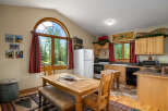 Experience rustic charm in this cozy kitchen featuring a large wooden dining table perfect for family meals.