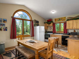 Experience rustic charm in this cozy kitchen featuring a large wooden dining table perfect for family meals.