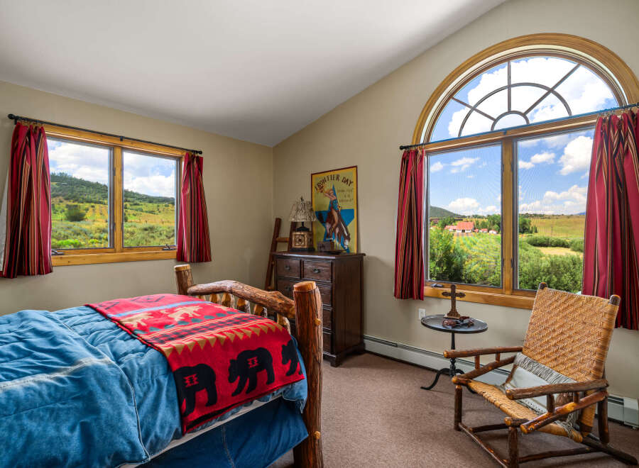 Experience rustic charm in this inviting bedroom, featuring a cozy log bed adorned with a bear-themed blanket.