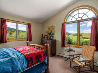 Experience rustic charm in this inviting bedroom, featuring a cozy log bed adorned with a bear-themed blanket.