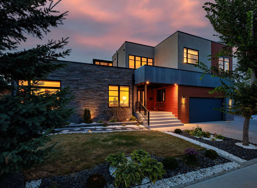 Experience modern luxury in this stunning multi-level home, featuring a striking stone facade and warm wood accents.