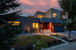 Experience modern luxury in this stunning multi-level home, featuring a striking stone facade and warm wood accents.