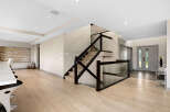 Experience modern luxury in this stunning home featuring a sleek staircase with glass railings and dark wood accents.
