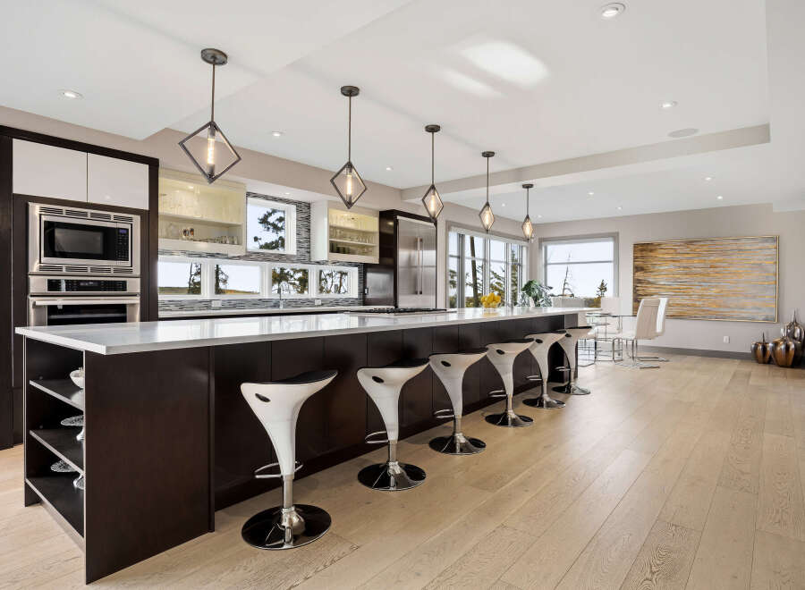 Experience luxury in this modern kitchen featuring a spacious island with sleek bar stools, perfect for entertaining.