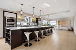 Experience luxury in this modern kitchen featuring a spacious island with sleek bar stools, perfect for entertaining.