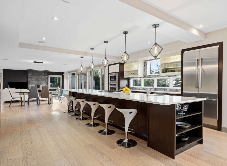 Experience luxury living in this stunning modern kitchen, featuring a spacious island with bar seating and sleek pendant lighting.