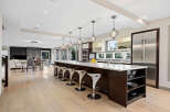 Experience luxury living in this stunning modern kitchen, featuring a spacious island with bar seating and sleek pendant lighting.