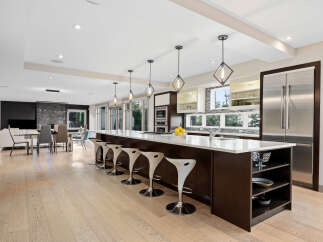 Experience luxury living in this stunning modern kitchen, featuring a spacious island with bar seating and sleek pendant lighting.
