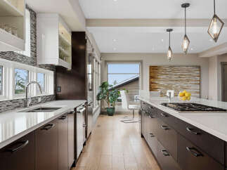 Experience luxury in this modern kitchen featuring sleek dark wood cabinetry and pristine white quartz countertops.