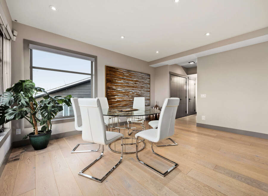 Experience modern dining with this elegant glass-top table and sleek white chairs, perfect for intimate gatherings.