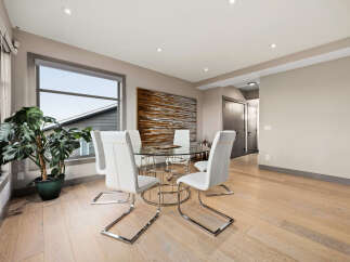 Experience modern dining with this elegant glass-top table and sleek white chairs, perfect for intimate gatherings.