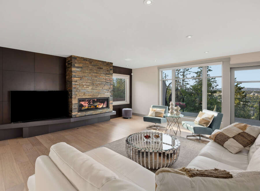 Experience modern luxury in this stunning living room, featuring a sleek entertainment unit and a captivating stacked stone fireplace.
