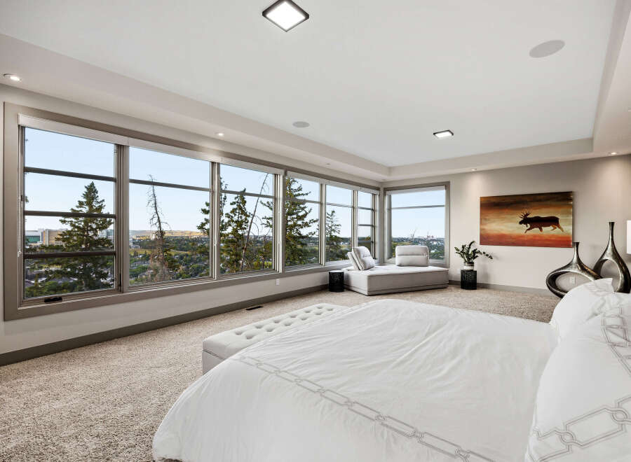 Experience breathtaking panoramic views from this luxurious master suite, featuring expansive windows that showcase the stunning landscape.
