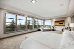 Experience breathtaking panoramic views from this luxurious master suite, featuring expansive windows that showcase the stunning landscape.